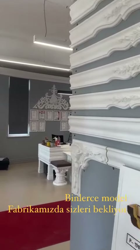 Kartonpiyer standının önünde ürün çizimleri taşıyan pano bulunuyor