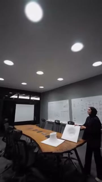 Sunucu armatür numunelerinin yanında tavandaki spotlara doğru bakıyor
