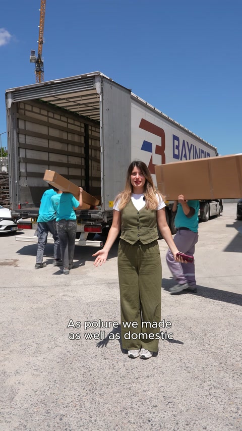 Sunucu konuşurken ekip büyük ambalajları sevkiyat aracına yüklüyor