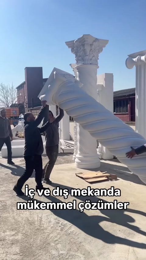 Büyük burgulu dekoratif sütun birkaç kişi tarafından taşınıyor