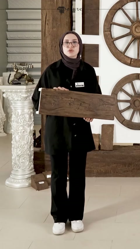Ahşap damarlı tavan kirişi örneği iki elle sergileniyor