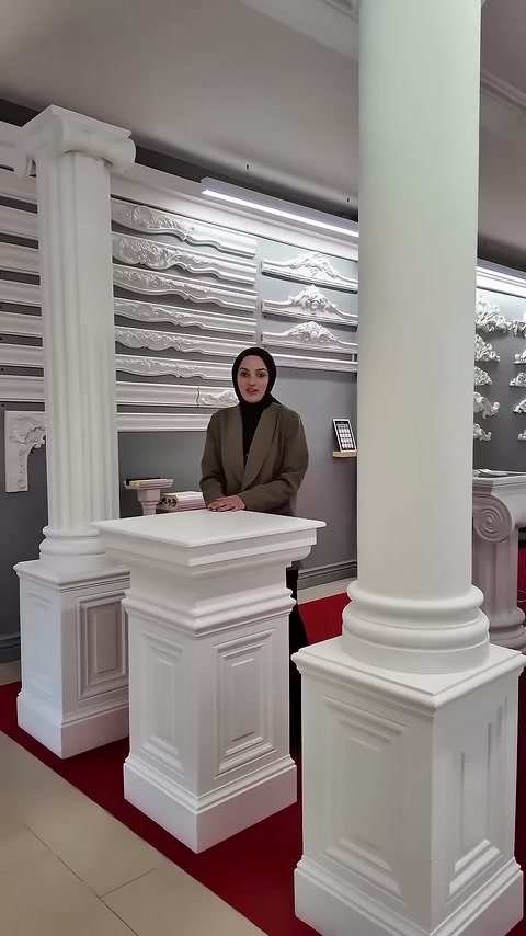 Büyük silindirik sütun ön planda kaide modelleri arkada bulunuyor