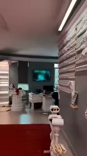 Kırmızı halı showroomdaki çalışma masalarına ve sütunlara uzanıyor