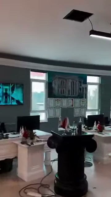 Showroom ofisinde siyah sütun formu ve beyaz masalar bulunuyor
