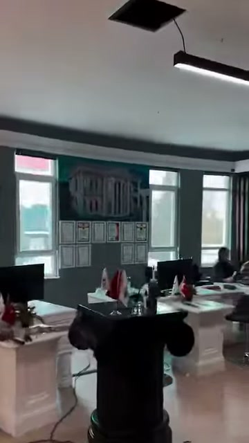 Tavan aydınlatmaları altında sütunlu çalışma masaları sıralanıyor