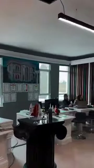 Geniş ofis bölümünde dekoratif kaideler ve masa düzeni görülüyor