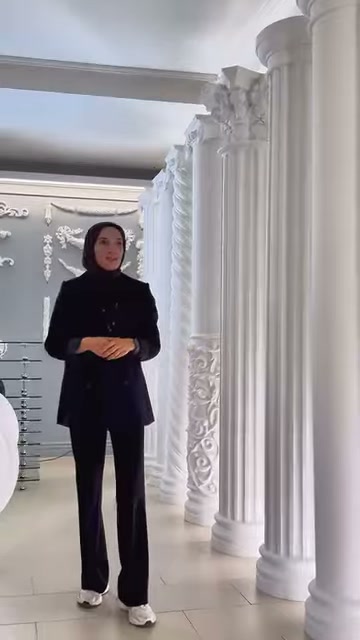 Yivli sütunlar ve süslü çerçeve elemanları tanıtıcının arkasında görülüyor.