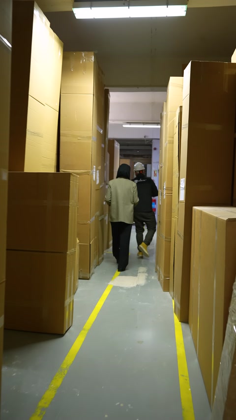 Paketlenmiş ürünlerin sıralandığı depo koridorunda fabrika gezisi