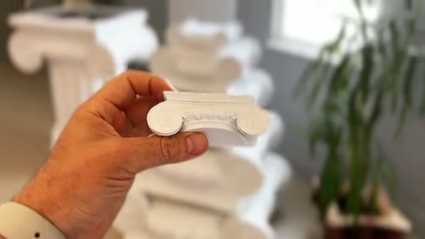 Beyaz kıvrımlı profil parçası, sergi alanında yatay biçimde tutuluyor.