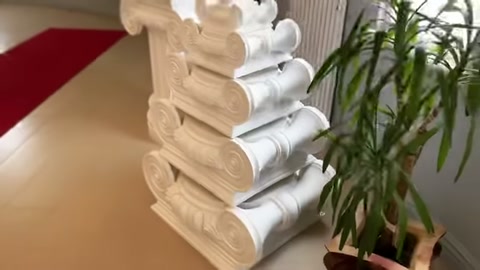 Beyaz poliüretan sütun başlıklarının çok katlı teşhir düzeni gösteriliyor.