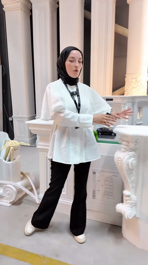 Beyaz dekoratif şömine, sütun modelleri önünde tanıtılıyor