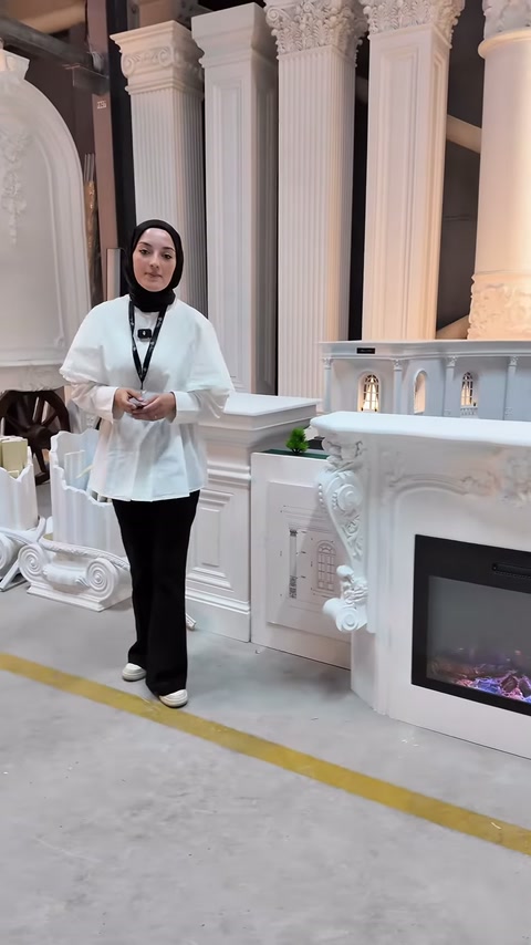 Sunucu beyaz şömine modelinin yanında ürün anlatımını sürdürüyor