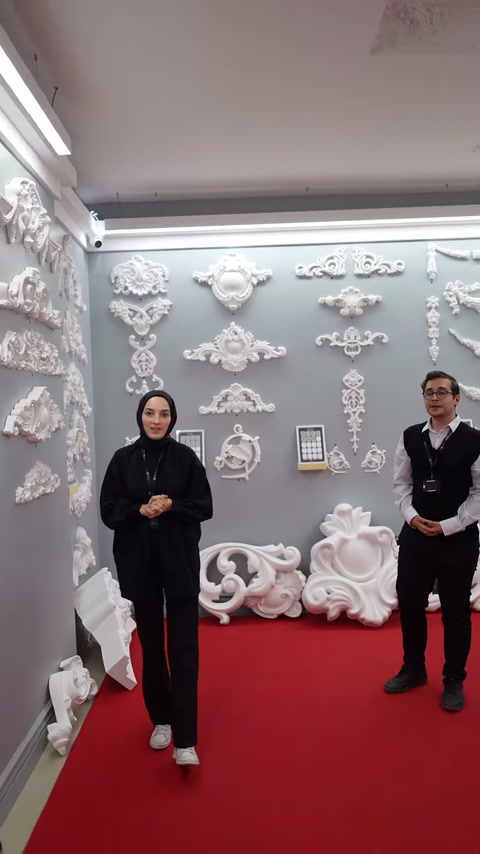İki sunucu beyaz kabartmalı dekor koleksiyonu önünde duruyor