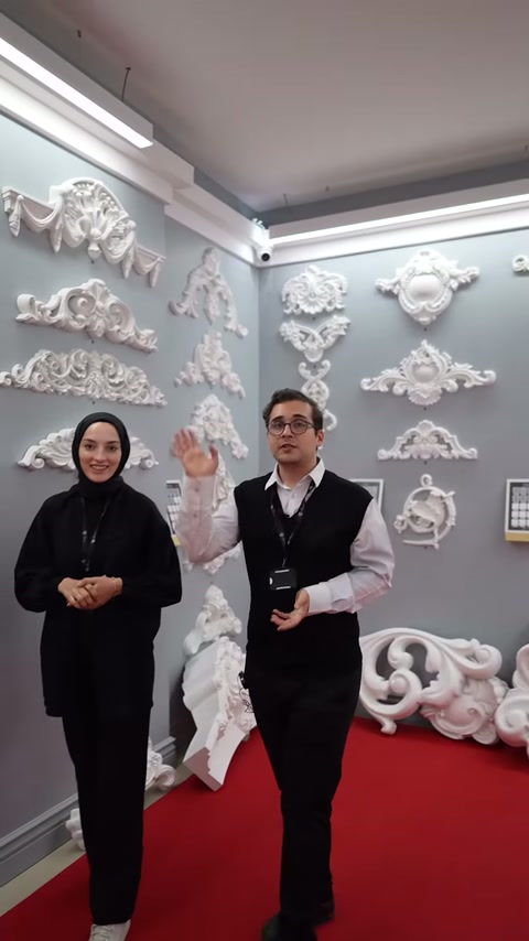 İki sunucu üst bölümdeki uzun kabartmalı motifleri işaret ediyor
