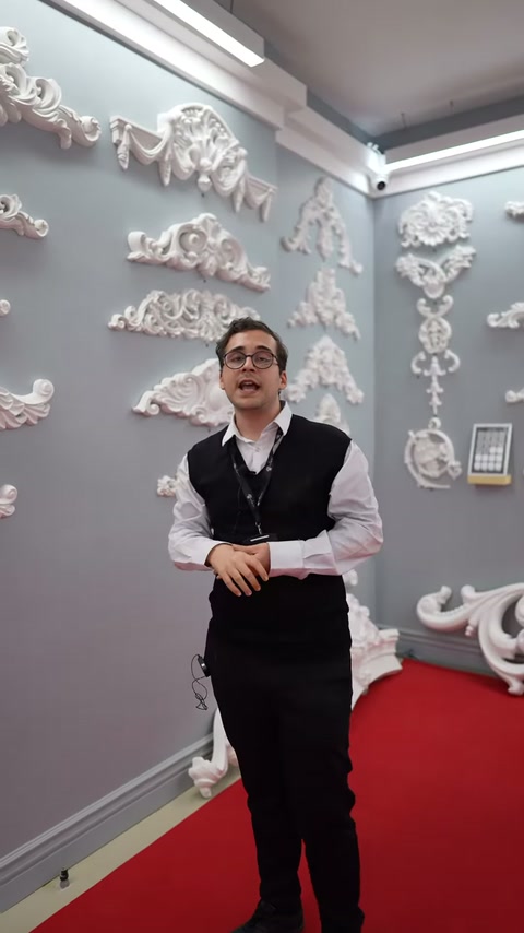 Sunucu farklı biçimlerdeki beyaz kabartmaları pano önünde açıklıyor