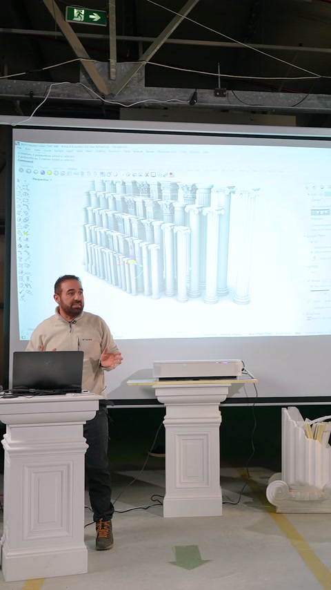 Sunucu, farklı yükseklikteki pilaster kaideleri önünde açıklama yapıyor.