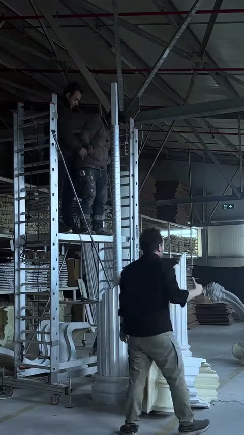Uzun beyaz sütun parçası kaide üzerindeki gövdeye yaklaştırılıyor.