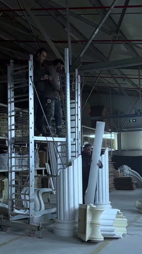 Poliüretan sütun gövdesi montaj için iki usta tarafından kaldırılıyor.